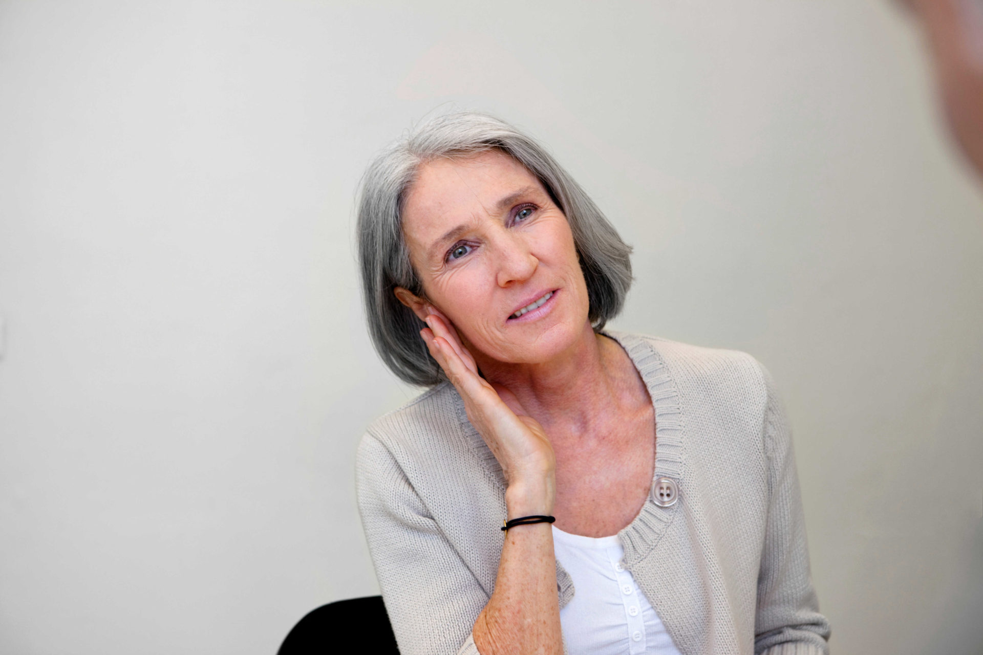 woman struggling to listen through one of her ears 