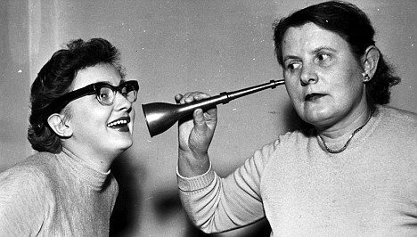 woman using ear trumpet as a hearing aid