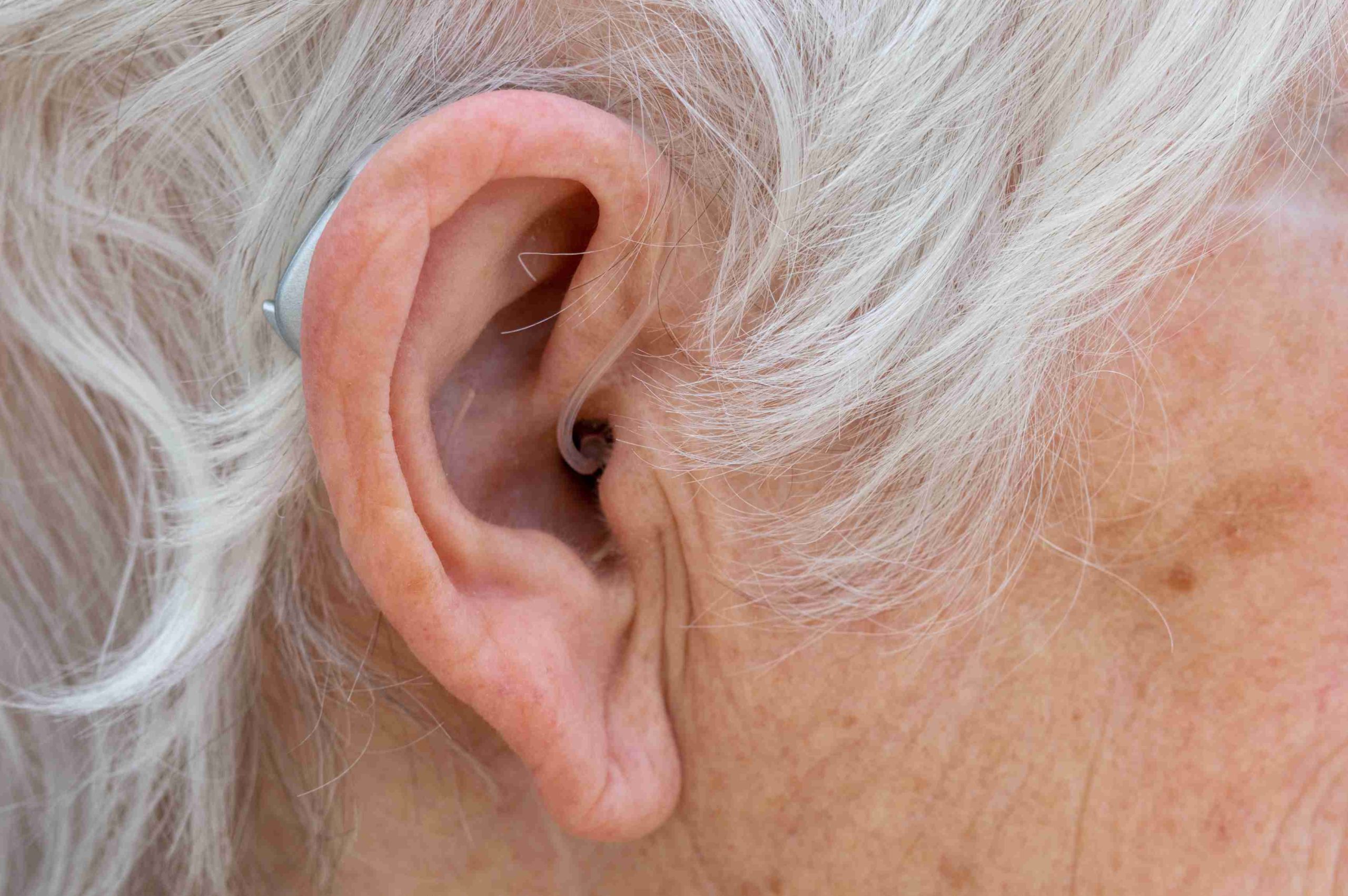 Receiver in canal hearing aid being worn by a woman
