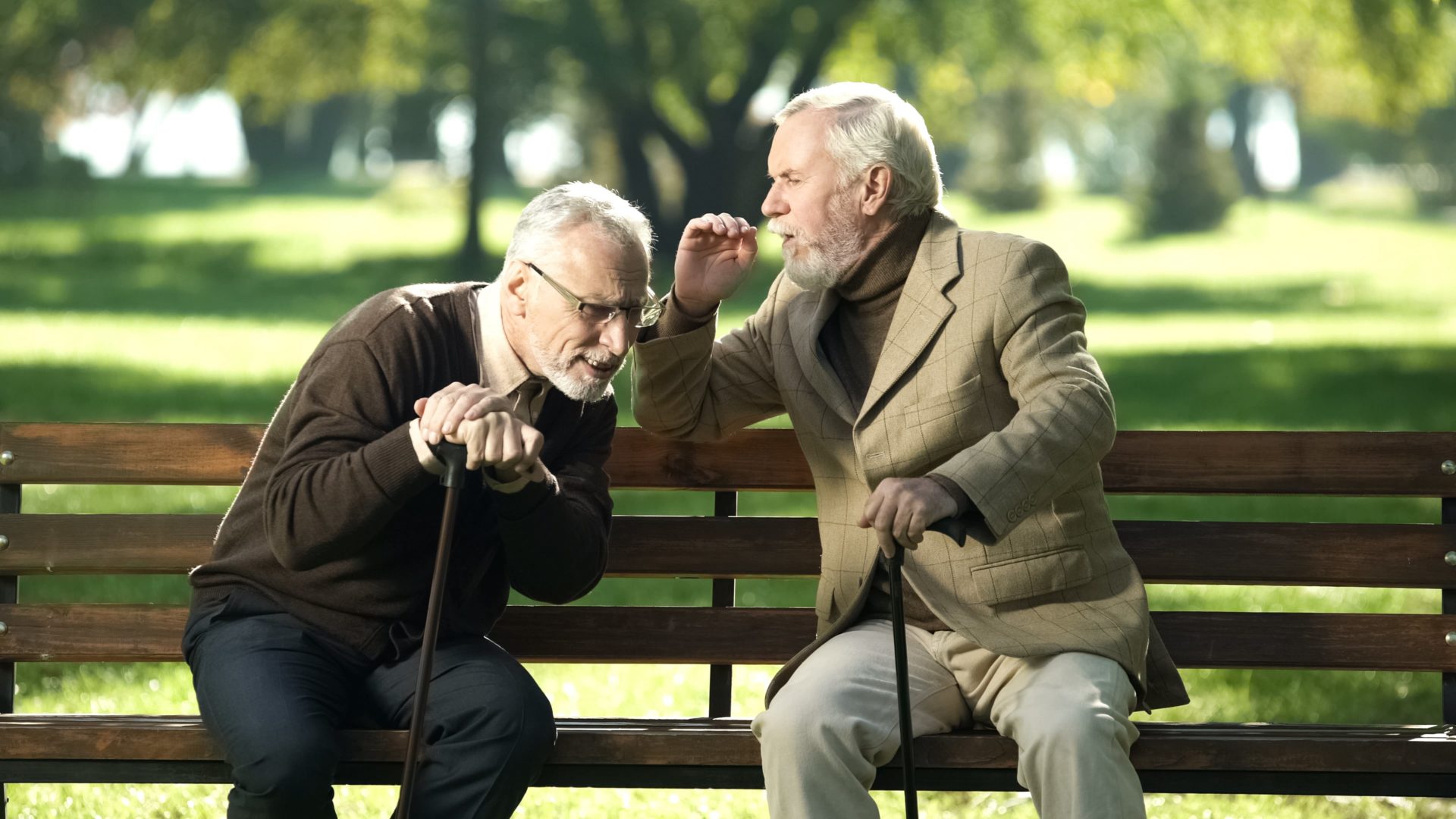 old man struggling to hear his friend