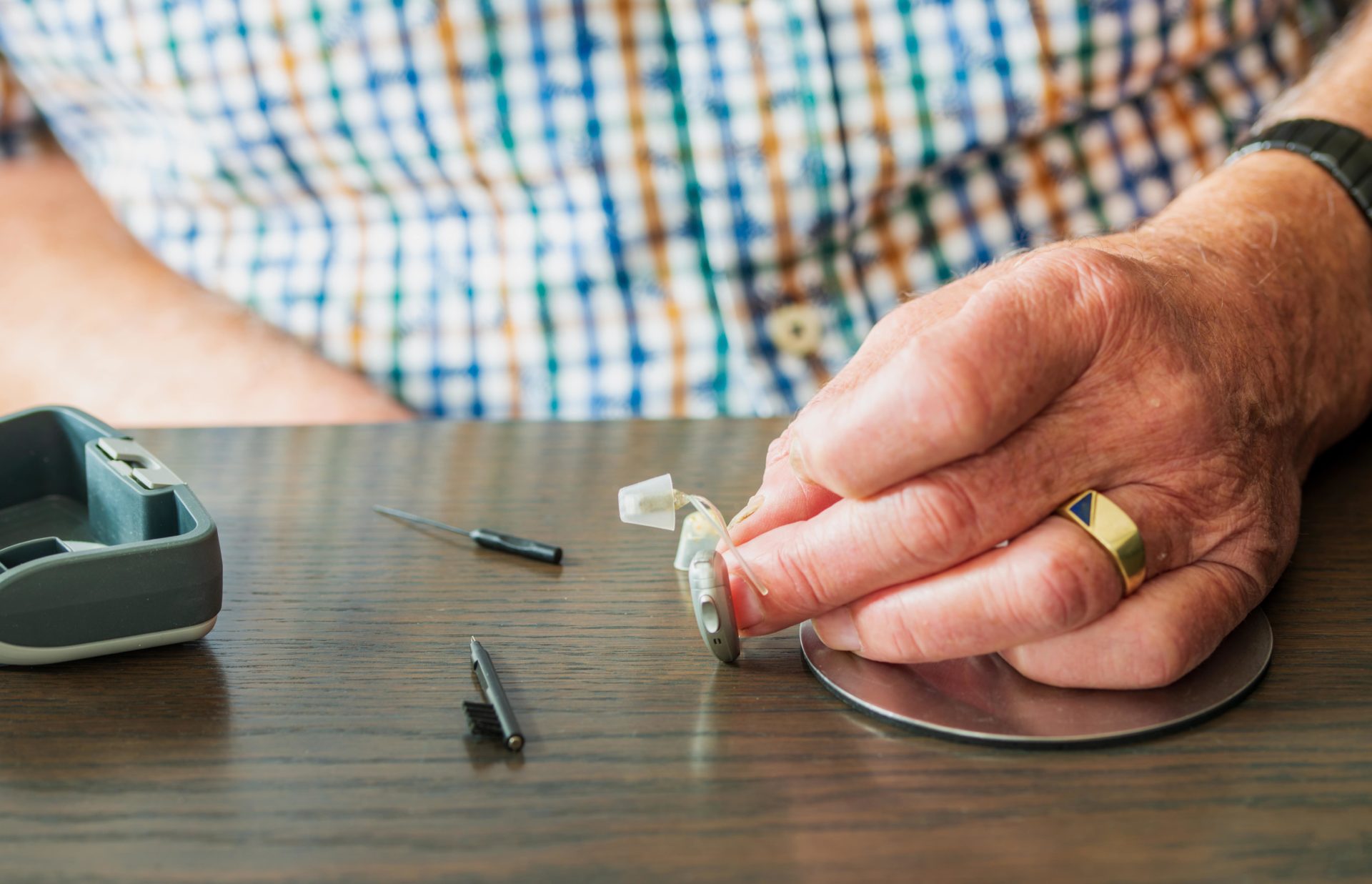 Elderly man cleaning hearing aids