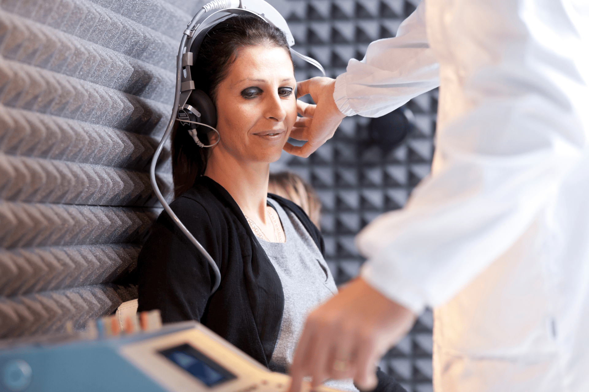 Women sitting in an enclose room having a hearing test