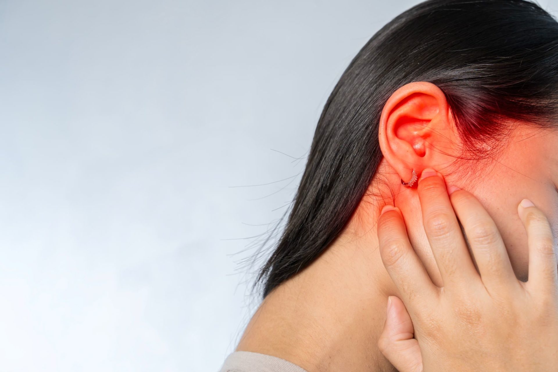 Woman suffering from ear pain due to built up earwax