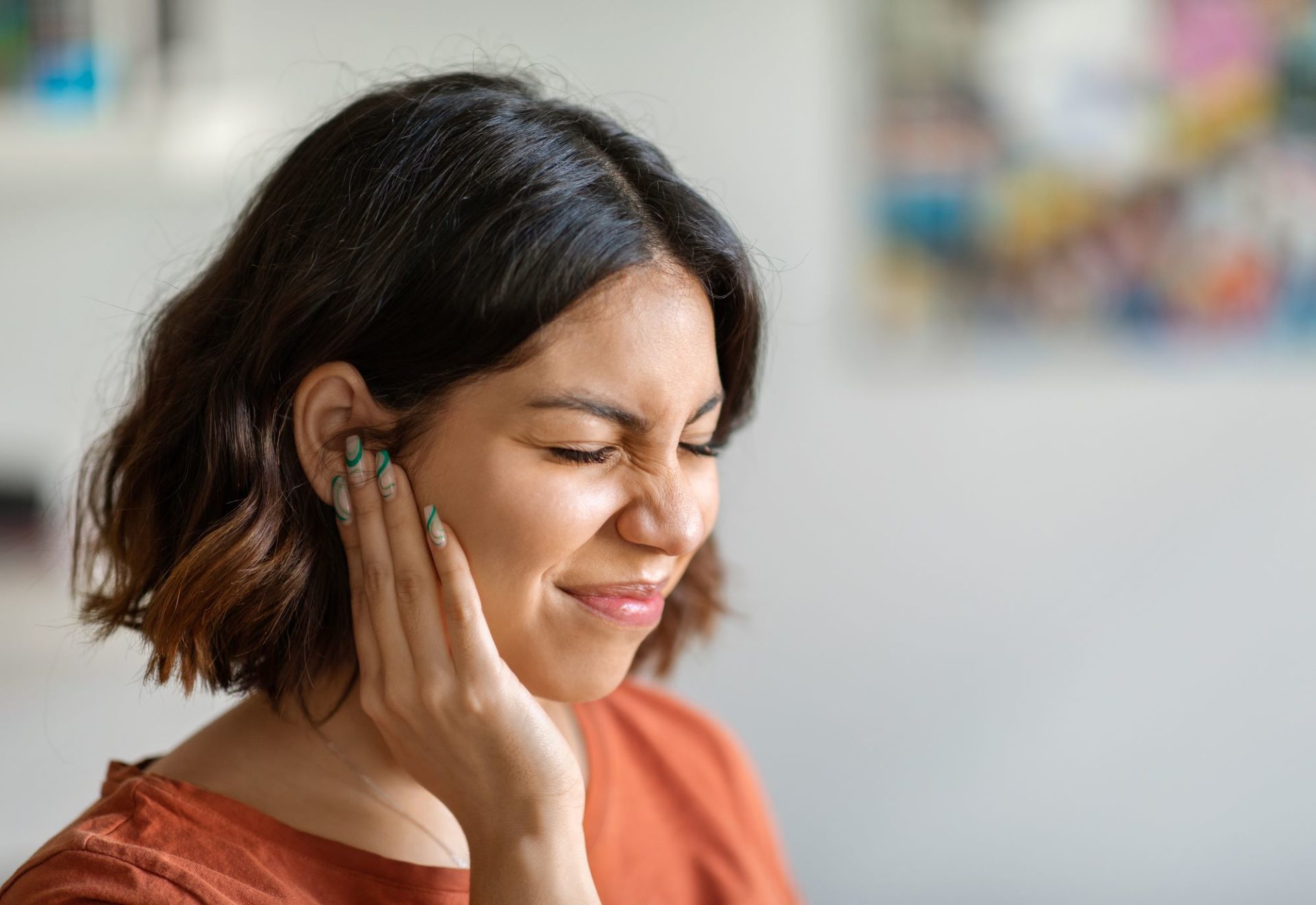 A woman holding her ear in pain